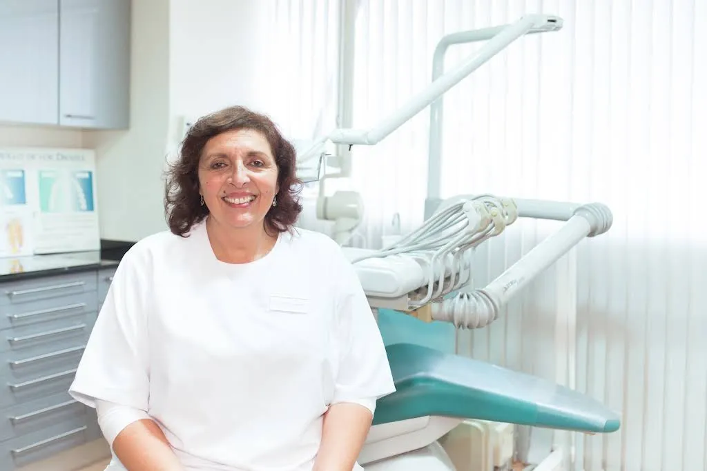 La doctora Laura D'Orazio Ferreyra sonriendo junto al sillón dental de Odontos, Clínica Dental