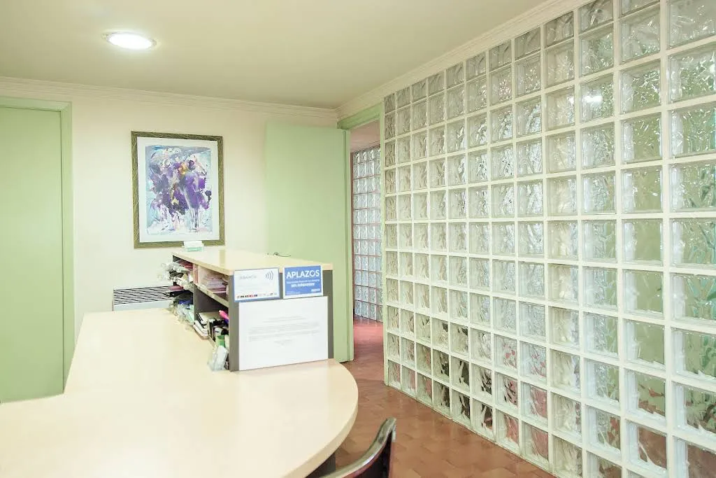 Recepción de Odontos, Clínica Dental, con pared de bloques de vidrio